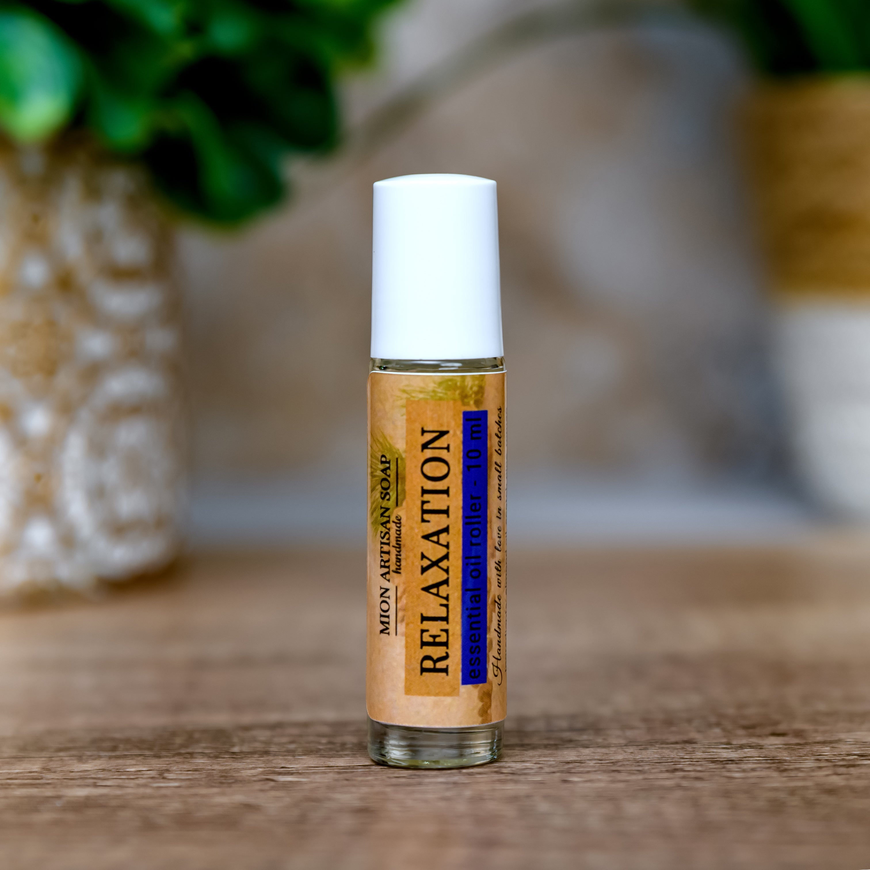 Roll-on bottle labeled 'Relaxation' on a wooden surface with greenery in the background