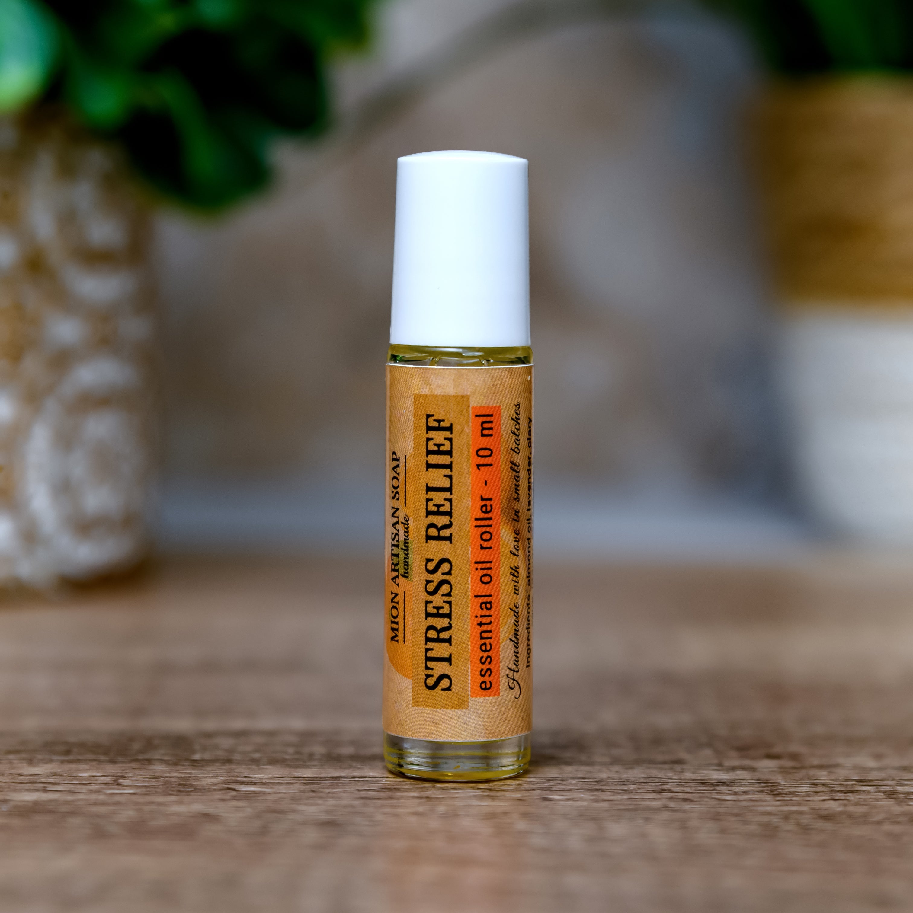 Roll-on bottle labeled 'Stress Relief' on a wooden surface with a blurred natural background
