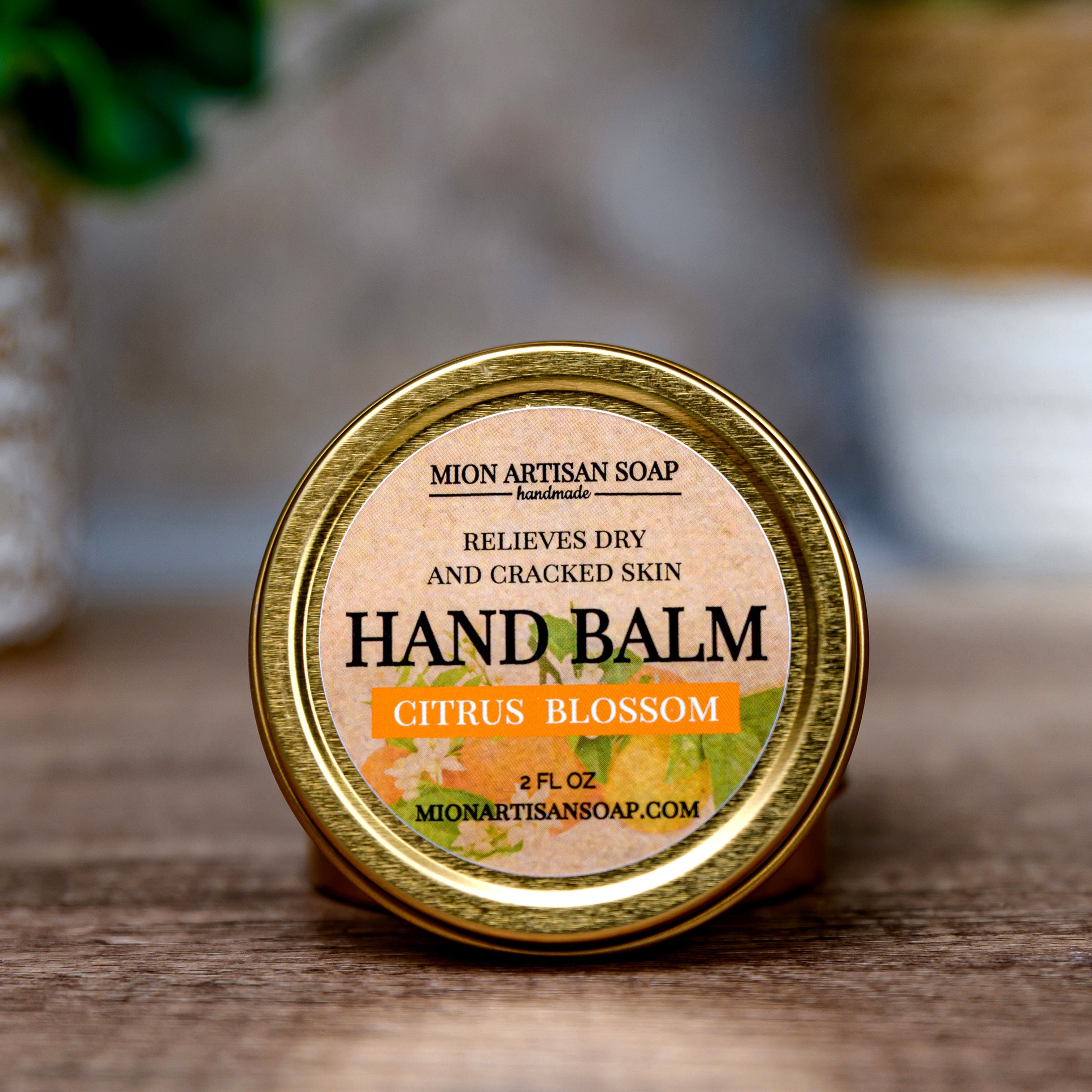 Hand balm container with 'Mion Artisan Soap' label on a wooden surface.
