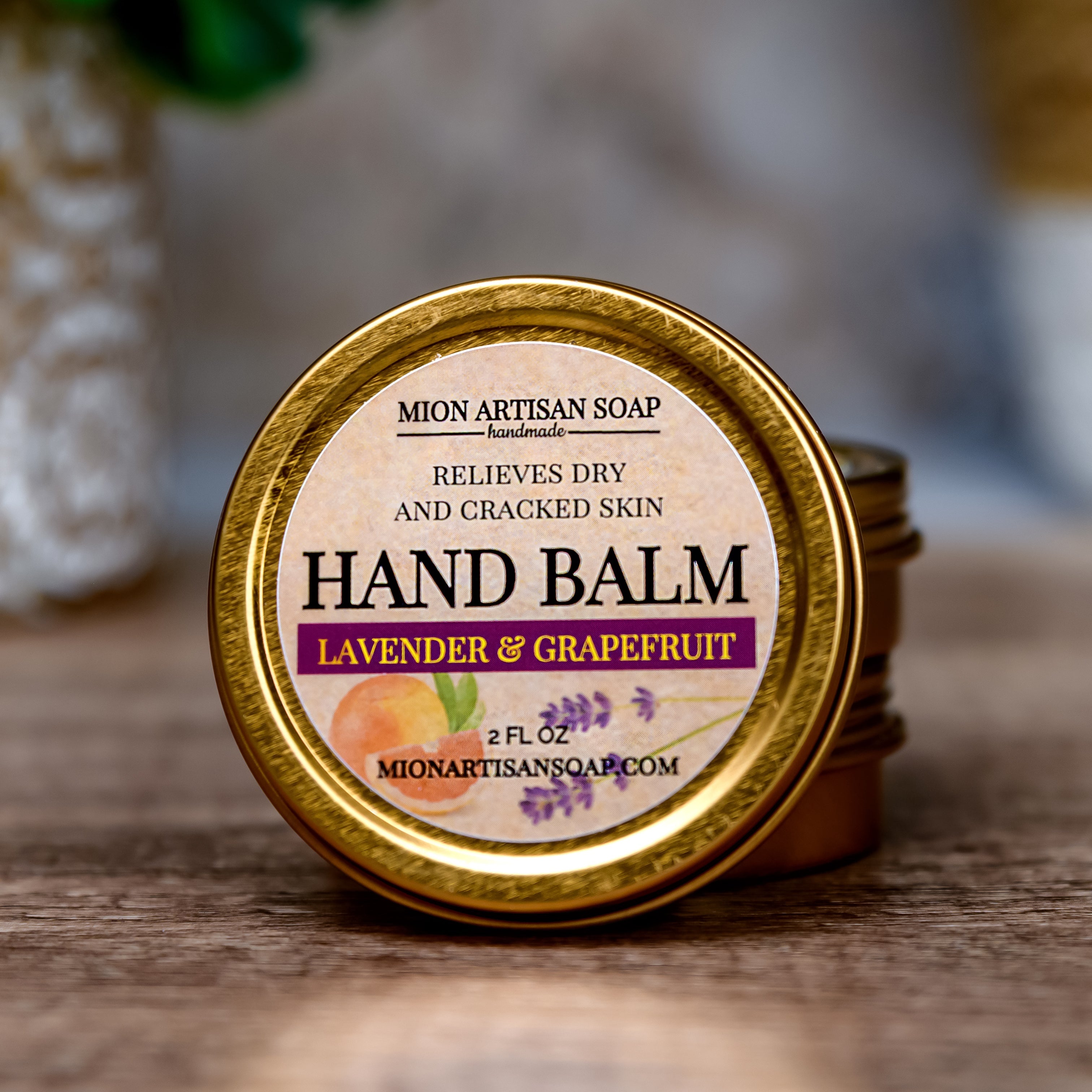 Hand balm container with lavender and grapefruit scent on a wooden surface