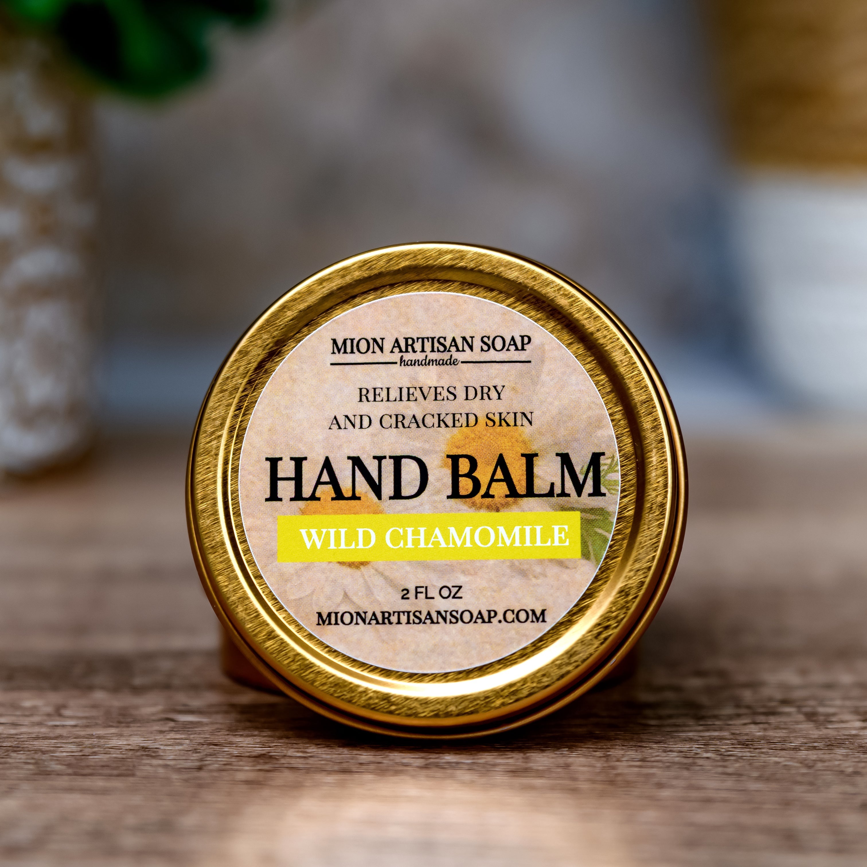 Hand balm container with 'Mion Artisan Soap' label on a wooden surface.