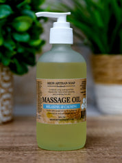 Bottle of Mion Artisan Soap massage oil on a wooden surface with plants in the background