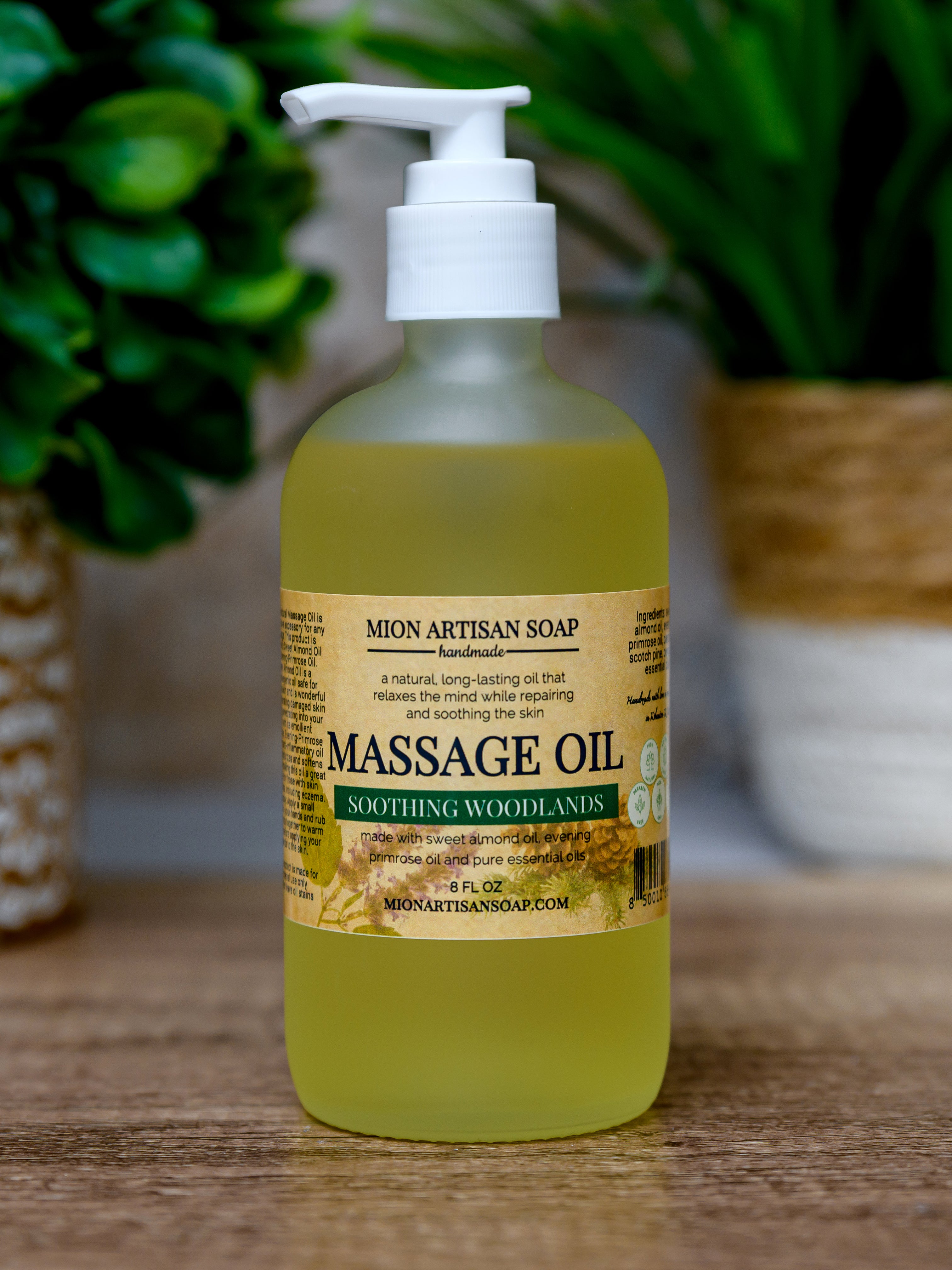 Massage oil bottle with pump on a wooden surface, blurred greenery in the background