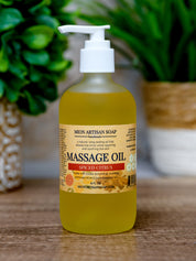 Bottle of massage oil with a pump on a wooden surface, green plants in the background